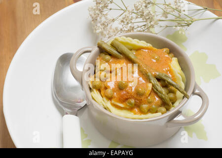 Cocotte, Italien pâtes aux tomates asperges et petits pois sur fond de bois Banque D'Images