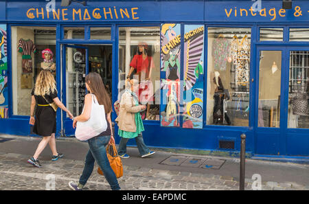 Femme passant des passes en face de chine machine vintage fashion store dans le quartier de Montmartre, rue des Martyrs, Paris Banque D'Images