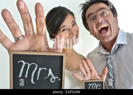 Nouvelle mariée hispanic couple holding signs disant ' Mr' et ' Mme' dans leurs mains. Banque D'Images