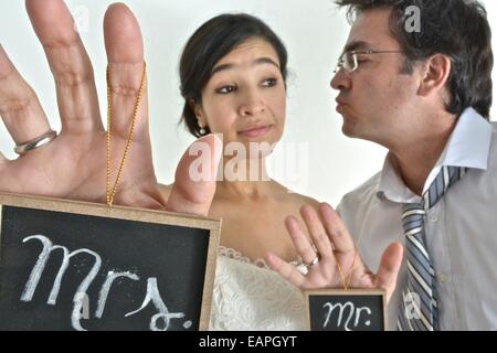 Nouvelle mariée hispanic couple holding signs disant ' Mr' et ' Mme' dans leurs mains. Banque D'Images