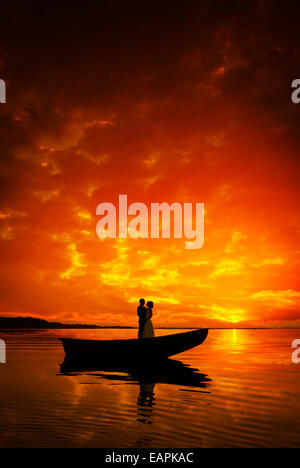 Silhouette d'un couple dans boat on River dans le coucher du soleil, belle skyes Banque D'Images