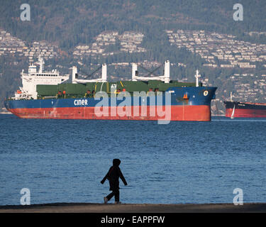 Silhouetté beach walker jour d'automne froid banques espagnoles de cargos à l'ancre l'Inlet Burrard Vancouver Canada Banque D'Images