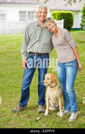 Happy senior couple chien devant leur maison Banque D'Images