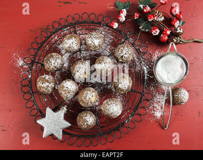 Fudge au chocolat et au caramel de Noël cookies sur vintage grille de cuisson rouge foncé sur fond de bois rustique avec des décorations de fête Banque D'Images