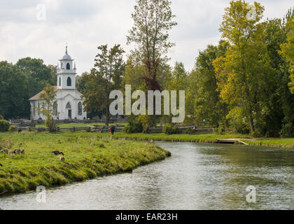 L'église du village avec ruisseau. L'église du village à clin blanc avec le petit ruisseau de village en face d'elle. Banque D'Images