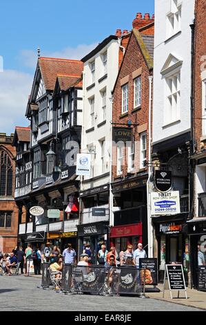 Cafe de la chaussée à l'extérieur de vieux magasins et bâtiments le long Bridge Street, Chester, Cheshire, Angleterre, Royaume-Uni, Europe de l'Ouest. Banque D'Images