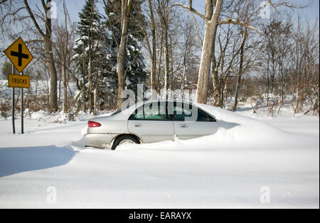 Lancaster, New York, USA. 19 Nov, 2014. Une voiture abandonnée a été partiellement enterré dans un fossé sur le à Lancaster, New York, États-Unis, 19 novembre 2014. Jusqu'à six pieds de neige est tombée sur la région le mardi 18 novembre, les échouages des dizaines d'automobilistes sur les routes et causant des morts. Photo : Mike Bradley/dpa/Alamy Live News Banque D'Images