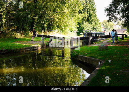 L'homme et la femme pour verrouiller la porte d'ouverture à Hungerford Bateau étroit sur le canal Kennet et Avon Banque D'Images