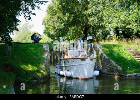 Bateau à moteur en passant par les portes d'écluses à Hungerford sur le canal Kennet et Avon Banque D'Images