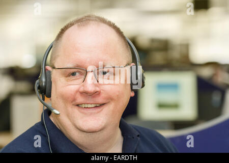 Centre d'appels - Middle-aged man wearing casque audio dans l'entreprise de télémarketing Banque D'Images