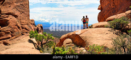 Les randonneurs à l'égard de Montagnes La Sal entre des falaises de grès rouge, Arches-Nationalpark, près de Moab, Utah Banque D'Images