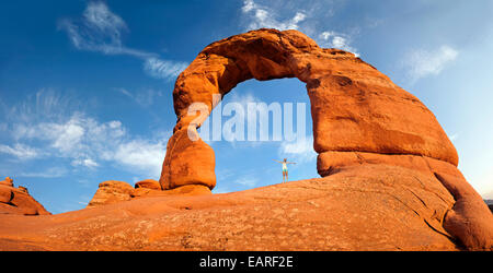 Woman standing under Delicate Arch natural stone arch, Arches-Nationalpark, près de Moab, Utah, United States Banque D'Images