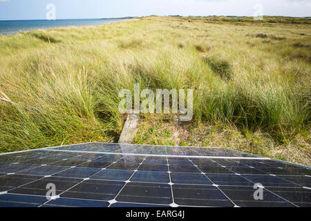 Un panneau solaire génère de l'électricité pour alimenter une clôture électrique qui protège une colonie de Sternes arctiques et peu près de Newton, Bas Norhumberland, UK. Banque D'Images