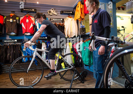 Un vendeur de montres comme un fait l'essai d'un vélo lors de cycles de vente de vélos indépendants Sommet & repair center Aberystwyth UK Banque D'Images