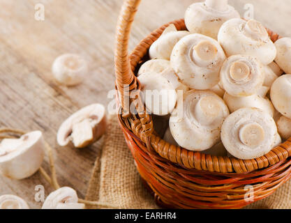 Les champignons sur une table en bois dans un panier. Selective focus Banque D'Images