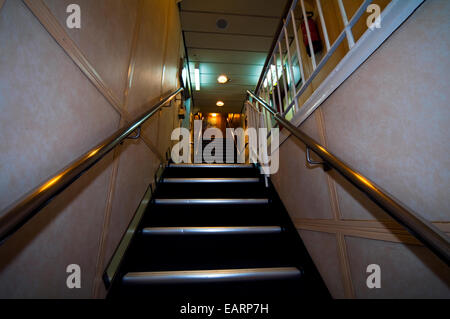 Un escalier avec main courante en laiton menant entre plate-formes sur un navire. Banque D'Images