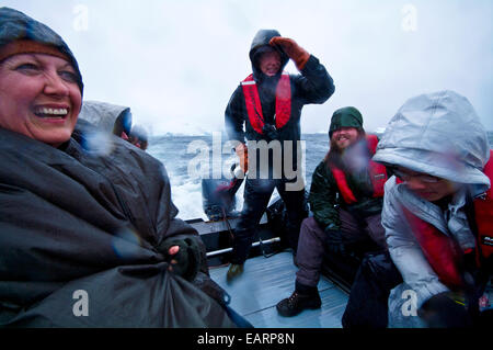 Les touristes profiter sauvage météo et une mer agitée dans un zodiac dans l'Antarctique. Banque D'Images