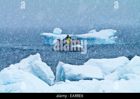 Les touristes atterrissent sur une île couverte de neige et de glace pendant un blizzard. Banque D'Images