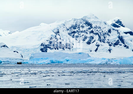 Les touristes en explorer d'icy bay sous des sommets enneigés dans un bateau gonflable. Banque D'Images