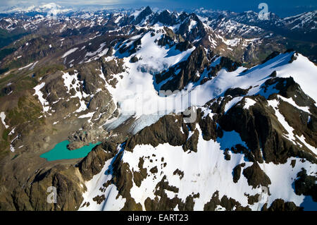 Un lac glaciaire turquoise bercé par la neige et la glace des pics drapés. Banque D'Images