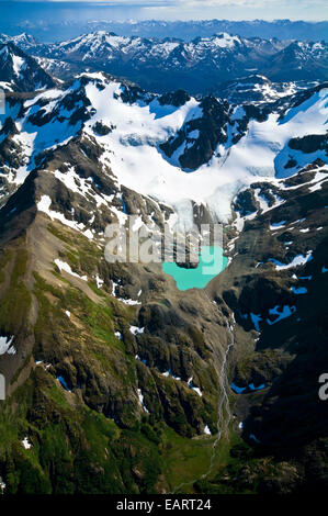 Un lac glaciaire turquoise bercé par la neige et la glace des pics drapés. Banque D'Images