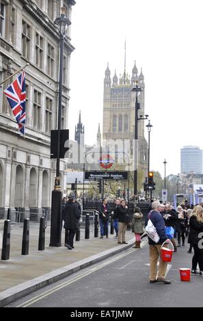 Homme avec appel de pavot à seaux World War One par Cénotaphe de la station Westminster Abbey et occupé avec la foule, Londres Banque D'Images