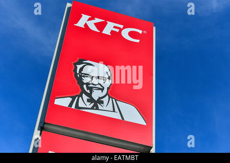 Stock Photo - KFC Kentucky Fried Chicken Drive Thru panneau rouge avec le Colonel Sanders sur route avec ciel bleu. Banque D'Images