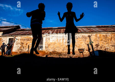 Les enfants sauter corde à l'un des profonds de Durban la vieille mine d'auberges de jeunesse dans la banlieue de Johannesburg, Afrique du Sud. Au cours de la Banque D'Images