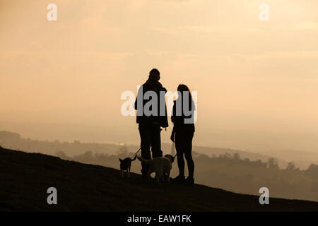 Jeune couple pour le coucher du soleil de la Camp sur les collines de Malvern, Herefordshire, Angleterre, RU Banque D'Images