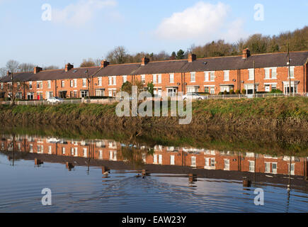 Vue du sud, d'une rangée de maisons mitoyennes reflétée dans l'usure de la rivière, Fatfield, Angleterre du Nord-Est, Royaume-Uni Banque D'Images