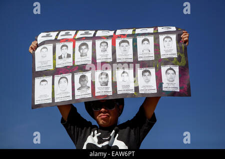 San Salvador, El Salvador. 20 novembre, 2014. Un étudiant est titulaire d'un placard pendant une manifestation pour protester contre la disparition de 43 étudiants de l'école rurale d'Ayotzinapa à San Salvador, dans le cadre de la célébration de la 104e anniversaire du début de la révolution mexicaine. Source : Xinhua/Alamy Live News Banque D'Images