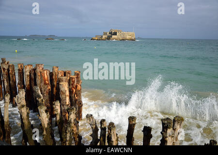 St Malo, Rising Tide, surf, brise-lames, Fort National dans l'arrière-plan. Banque D'Images