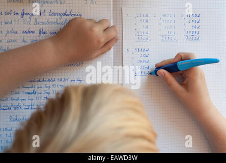 Un écolier de 10 ans est en train de faire ses devoirs de mathématiques. Banque D'Images