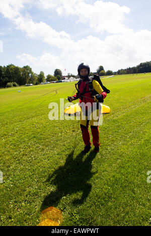 Cette fille débarque avec son parachutiste parachute et est maintenant très heureux d'être enregistrer sur le sol. Banque D'Images