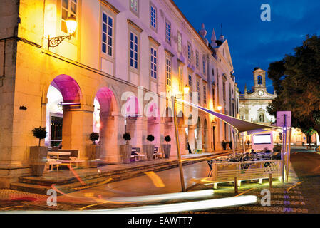 Portugal, Algarve, Faro : bâtiment historique du restaurant Columbus dans la nuit avec l'Arco da Vila en arrière-plan Banque D'Images