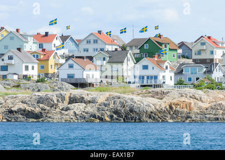 Maisons au bord de la rive portant des drapeaux suédois Banque D'Images