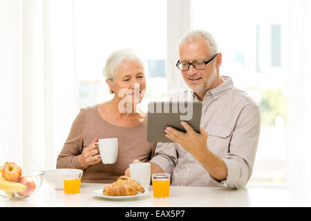 Happy senior couple with tablet pc at home Banque D'Images