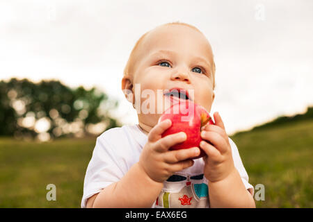 Smiling beautiful baby looking at camera et délicieux en plein soleil Banque D'Images