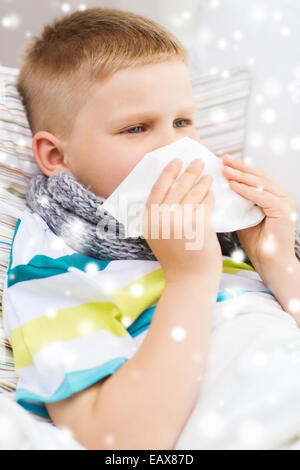 Mauvais Garçon blowing nose avec les tissus à la maison Banque D'Images