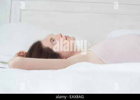 Woman lying on bed Banque D'Images