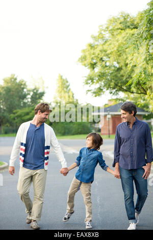 Boy walking avec ses pères à l'extérieur Banque D'Images