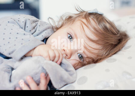 Baby Girl lying down, sucer le pouce, portrait Banque D'Images