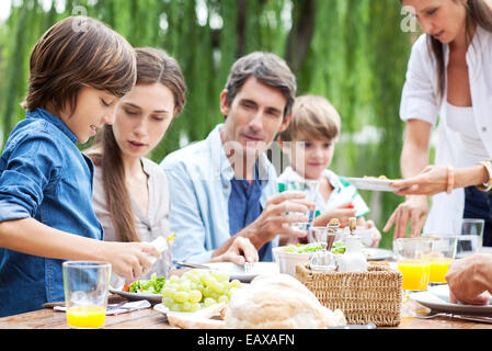 Famille manger ensemble au rassemblement en plein air Banque D'Images