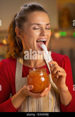 Portrait de jeune femme au foyer de la confiture d'orange dégustation Banque D'Images