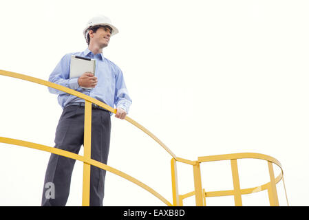 Engineer inspecting site industriel, low angle view Banque D'Images