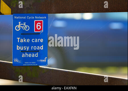 National cycle network avertissement cycliste de faire attention en traversant une route très fréquentée. Banque D'Images