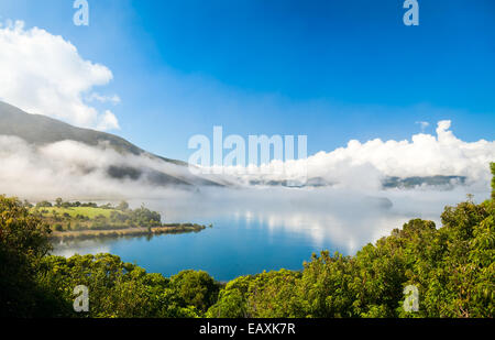 Nuages sur le lac d'Rotoaria, Nouvelle-Zélande. Les points sur la surface de l'eau sont des cygnes Banque D'Images