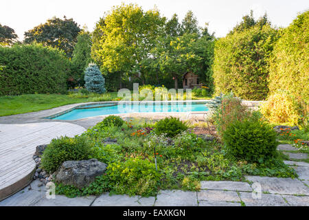 Rock arrière-cour jardin avec piscine privé résidentiel creusée et patio en pierre Banque D'Images