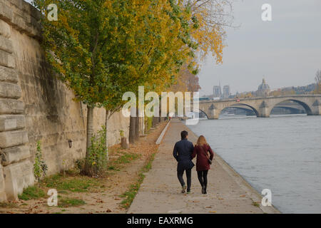 Paris, France. 21 Nov, 2014. Couple en train de marcher le long du fleuve la Seine sur un endroit frais mais ensoleillé en journée de novembre. Crédit : Paul Quayle/Alamy Live News Banque D'Images