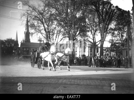 Cette photographie historique montre une démonstration d'équipement d'incendie à Central Square, Keene, New Hampshire. L'événement faisait partie de l'éducation à la sécurité publique, présentant les techniques et l'équipement de lutte contre l'incendie à la communauté locale. L'image capture un moment de l'histoire de la lutte contre les incendies aux États-Unis au début du XXe siècle. Banque D'Images